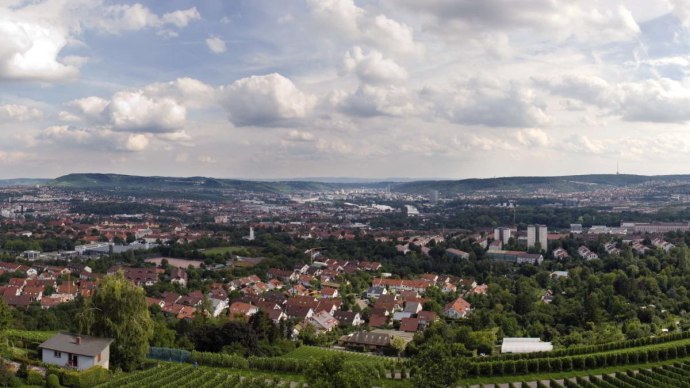 Panoramablick vom Burgholzhof auf Stuttgart mit Häusern, Weinbergen und bewölktem Himmel., © pjt56