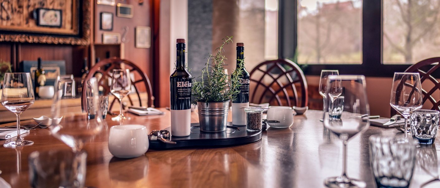 Eleganter Tisch im Restaurant des Stuttgart Marriott Hotel Sindelfingen, gedeckt mit Weingläsern, Besteck und dekoriert mit Kräutern und Weinflaschen., © Stuttgart Marriott Hotel Sindelfingen, Kilian Blees