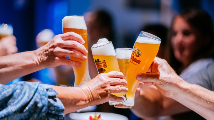 Mehrere Personen sto&szlig;en mit gef&uuml;llten Biergl&auml;sern an, im Hintergrund sind unscharf weitere Personen zu sehen., &copy; Stuttgart-Marketing GmbH, Thomas Niederm&uuml;ller