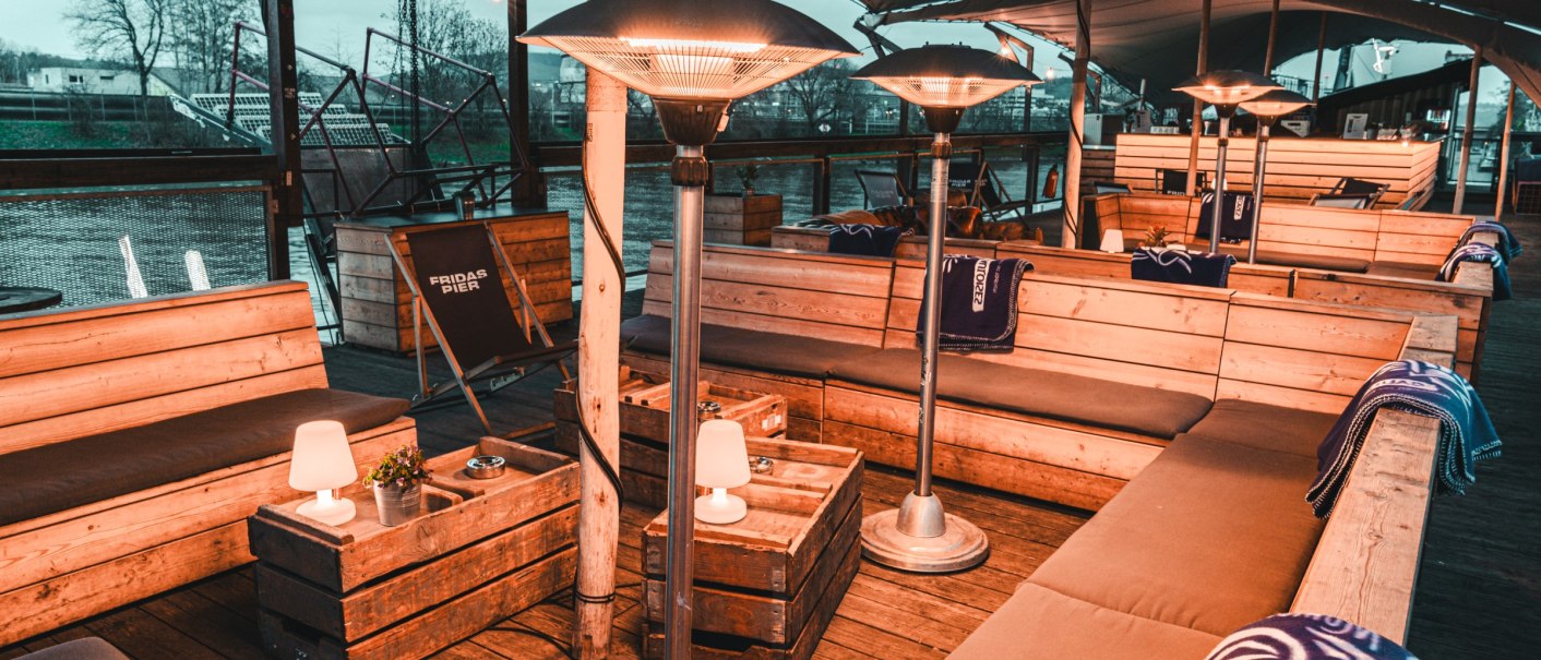 Comfortable seating on a covered upper deck with wooden benches, radiant heaters and blankets. A river can be seen in the background., © Fridas Pier Comfortable seating on a covered upper deck with wooden benches, radiant heaters and blankets. A river can be seen in the background., © Fridas Pier