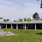 Die Stadthalle Korntal mit moderner Glasfassade und begrüntem Dach, umgeben von Rasen und Bäumen., © SK