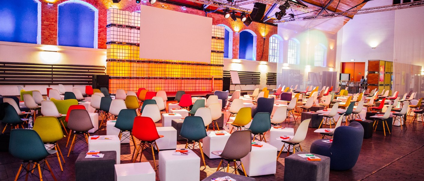 The Phoenixhalle in the R&ouml;merkastell is a modern event hall with colorful chairs, white tables and atmospheric lighting., &copy; Photo by Neon-Photography.com | Tobias Stoffels