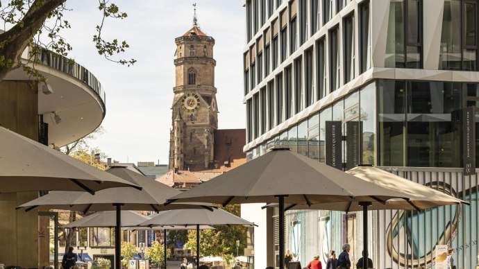 The Dorotheenquartier district in Stuttgart with modern buildings, parasols and the historic Stiftskirche church in the background., © Stuttgart-Marketing GmbH, Sarah Schmid The Dorotheenquartier district in Stuttgart with modern buildings, parasols and the historic Stiftskirche church in the background., © Stuttgart-Marketing GmbH, Sarah Schmid