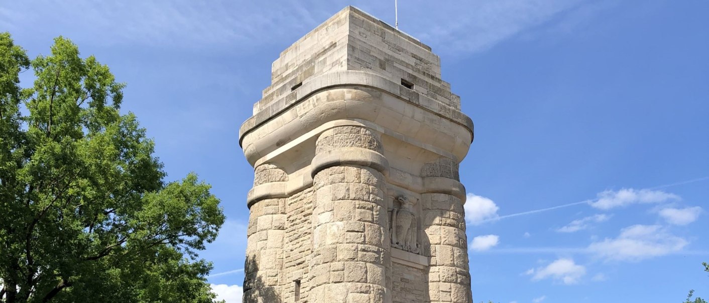 Der Bismarcksturm aus hellem Stein erhebt sich vor einem blauen Himmel, umgeben von grünen Bäumen., © Stuttgart-Marketing GmbH Der Bismarcksturm aus hellem Stein erhebt sich vor einem blauen Himmel, umgeben von grünen Bäumen., © Stuttgart-Marketing GmbH