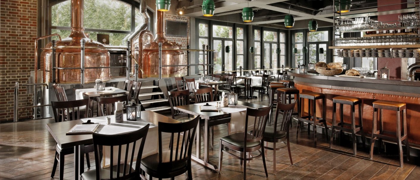 Gem&uuml;tliche Hausbrauerei mit Kupferkesseln, Holztischen und Bar. Gro&szlig;e Fenster lassen viel Licht herein. Rustikales Ambiente mit modernen Akzenten., &copy; Parkhotel Stuttgart Messe-Airport GmbH & Co KG