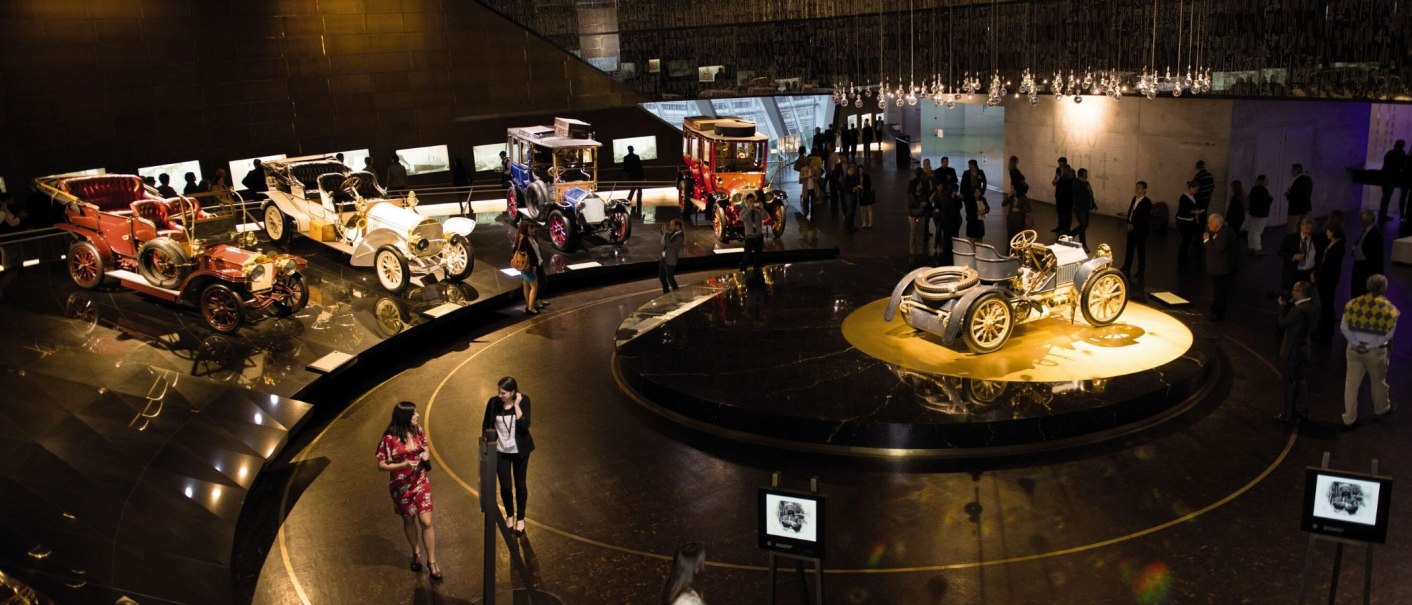 Interior view of the Mercedes-Benz Museum in Stuttgart with historic cars and visitors in an exhibition area., © Stuttgart-Marketing GmbH Sebastian Berger