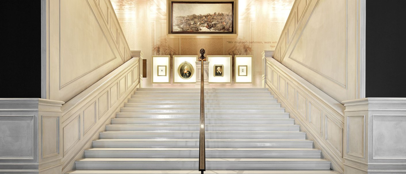 Eleganter Treppenaufgang im Haus der Geschichte Baden-Württemberg, dekoriert mit Gemälden und einer Büste an der Wand., © Daniel Stauch