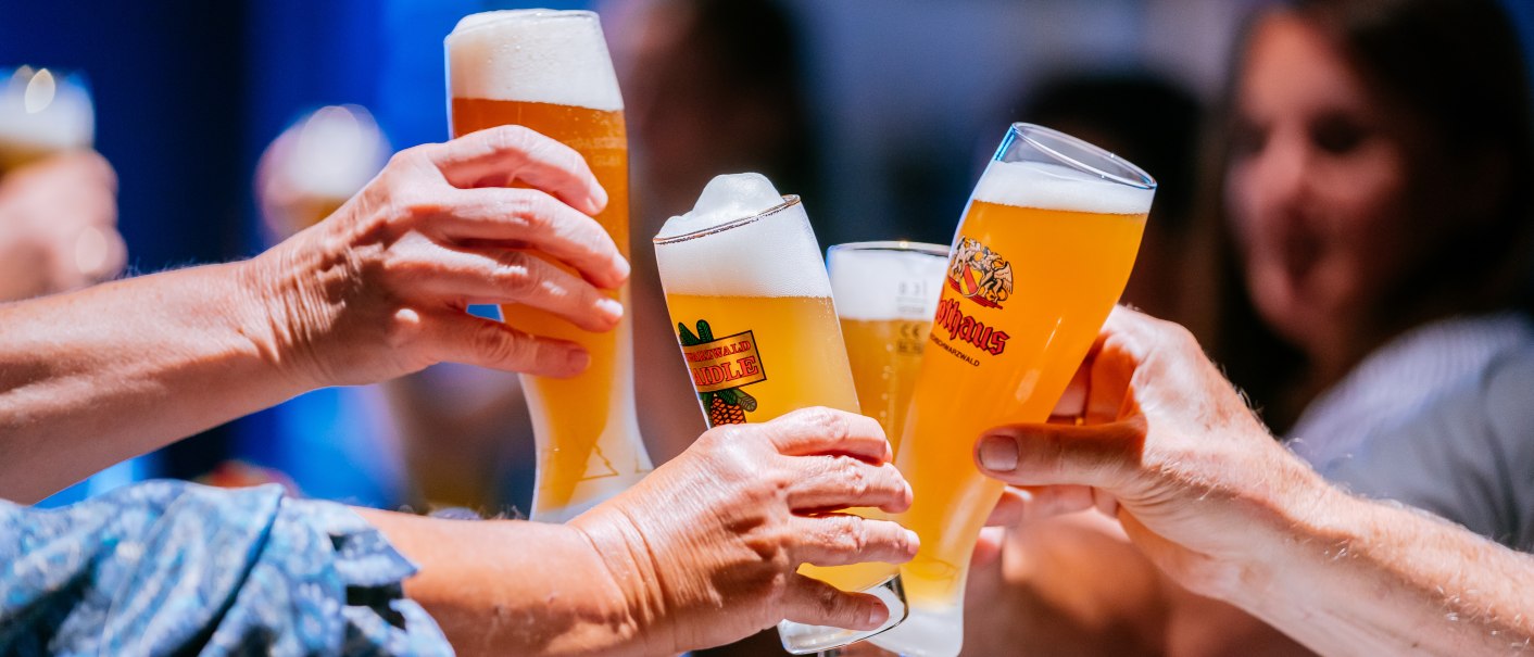 Mehrere Personen stoßen mit gefüllten Biergläsern an, im Hintergrund sind unscharf weitere Personen zu sehen., © Stuttgart-Marketing GmbH, Thomas Niedermüller Mehrere Personen stoßen mit gefüllten Biergläsern an, im Hintergrund sind unscharf weitere Personen zu sehen., © Stuttgart-Marketing GmbH, Thomas Niedermüller