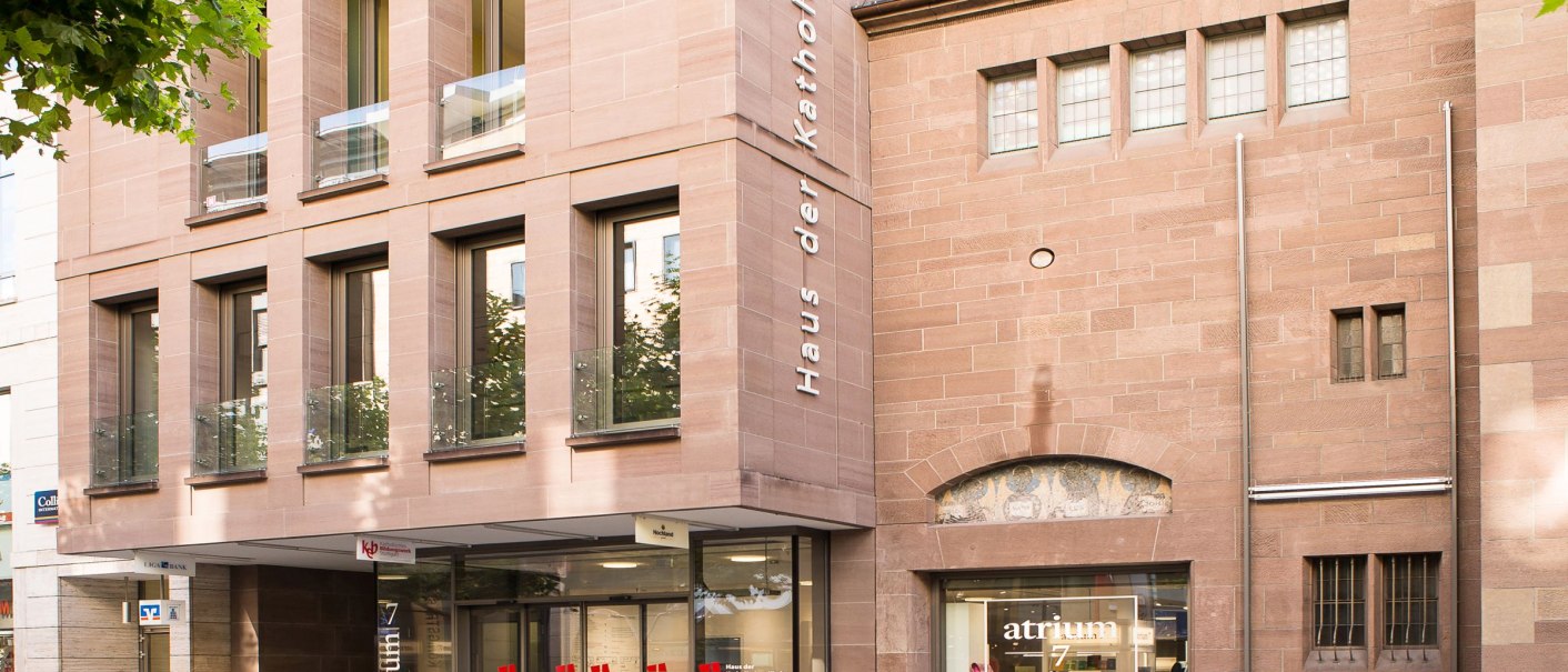 Moderne Fassade des Haus der Katholischen Kirche mit großen Fenstern und einem Eingang zum Atrium 7 Café., © hdkk_gf Moderne Fassade des Haus der Katholischen Kirche mit großen Fenstern und einem Eingang zum Atrium 7 Café., © hdkk_gf