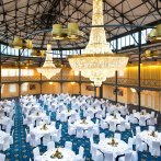 Eleganter Saal mit runden, weiß gedeckten Tischen, großen Kronleuchtern und blauer Teppichboden im Maritim Hotel Stuttgart., © Maritim Hotelgesellschaft mbH