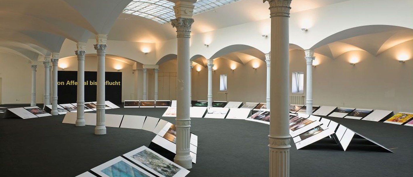 Ausstellung im Haus der Wirtschaft Baden-Württemberg mit weißen Säulen, gewölbter Decke und beleuchteten Informationstafeln auf dem Boden., © Wirtschaftministerium