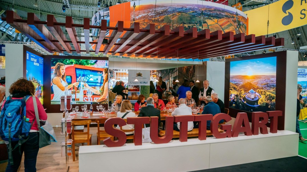 Messestand auf der CMT Messe 2025 mit gro&szlig;em Stuttgart-Schriftzug. Besucher sitzen an einem Tisch, im Hintergrund sind Bildschirme mit Stuttgart-Motiven., &copy; Stuttgart-Marketing GmbH, Thomas Niederm&uuml;ller