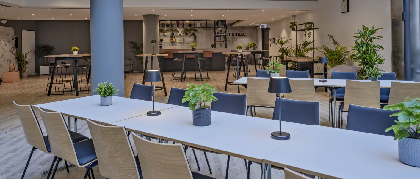 Modern conference room with long tables, chairs and lots of plants. A bar in the background and a clock on the wall., © R&D Dürr