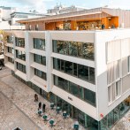 Moderne Fassade des Hauses des Tourismus mit gro&szlig;en Glasfenstern und einer Terrasse. Menschen spazieren auf dem gepflasterten Platz davor., &copy; SMG Stuttgart Marketing GmbH - Sarah Schmid