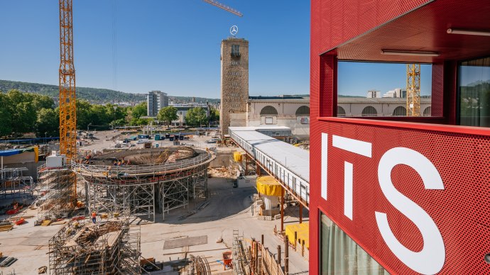 Baustelle in Stuttgart mit einem Turm und einem roten Geb&auml;ude im Vordergrund. Ein Kran und Bauarbeiten sind sichtbar, blauer Himmel im Hintergrund., &copy; ThomasNiederm&uuml;ller