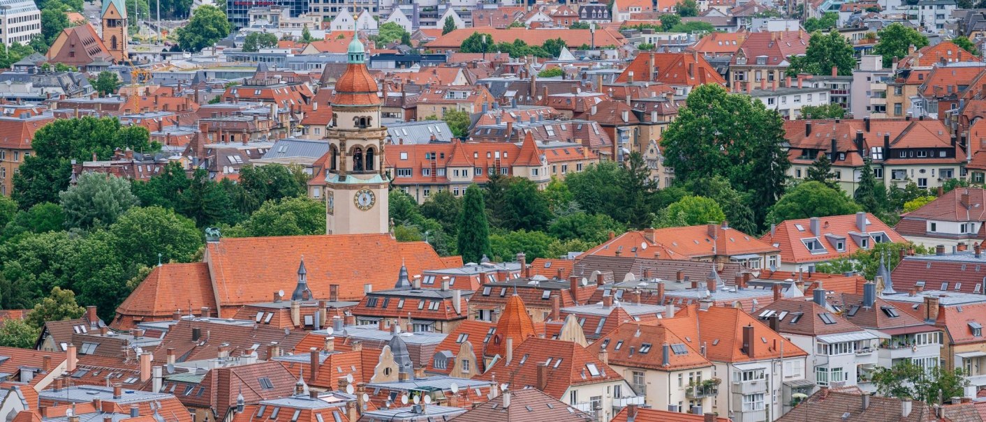 Blick über die Dächer von Stuttgart mit roten Ziegeln und einem markanten Kirchturm, umgeben von grünen Bäumen., © Thomas Niedermüller