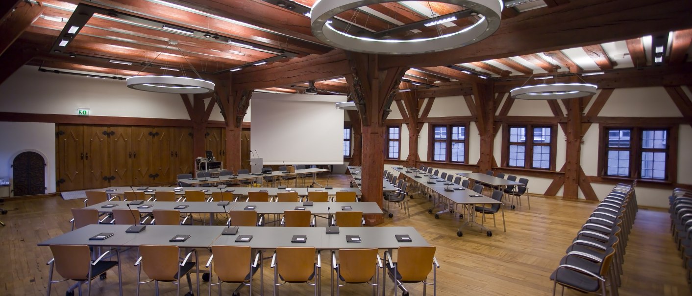 Ein historischer Sitzungssaal mit Holzbalken, Tischen und St&uuml;hlen. Gro&szlig;e Fenster und moderne Beleuchtung erg&auml;nzen das Ambiente., &copy; Esslingen live