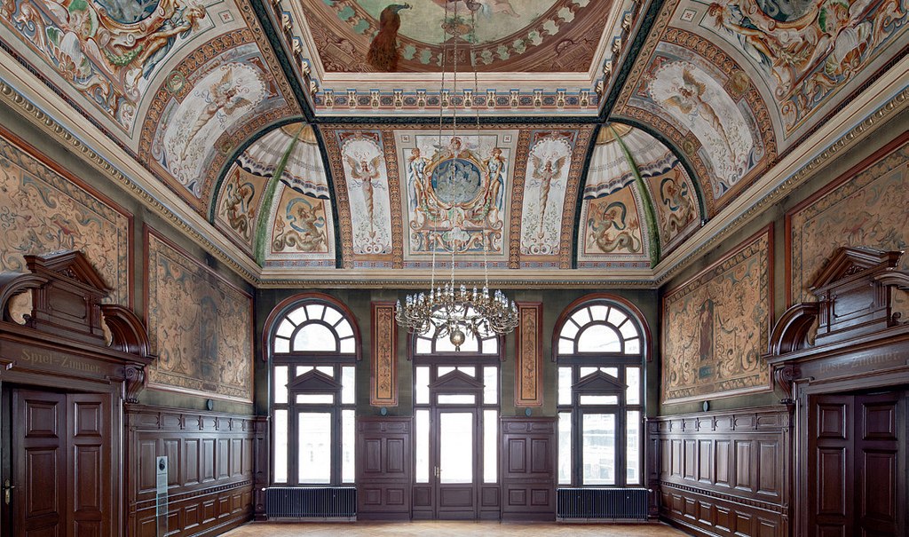 Magnificent hall with painted domed ceiling, large windows and wood paneling. A chandelier hangs from the ceiling., © Forum Koenig-Karls-Bad Magnificent hall with painted domed ceiling, large windows and wood paneling. A chandelier hangs from the ceiling., © Forum Koenig-Karls-Bad