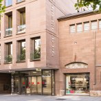 Moderne Fassade des Haus der Katholischen Kirche mit gro&szlig;en Fenstern und einem Eingang zum Atrium 7 Caf&eacute;., &copy; hdkk_gf