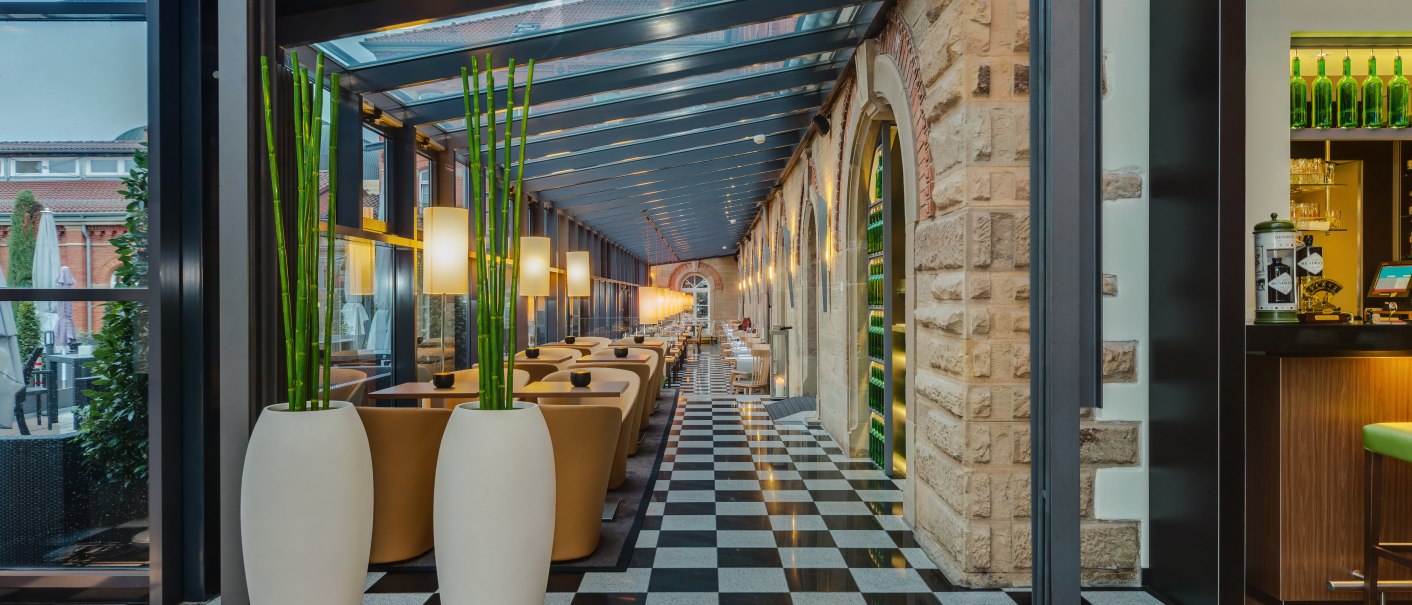 Elegant winter garden in the nestor Hotel Ludwigsburg with glass roof, black and white checkered floor, plants in white vases and cozy seating areas., &copy; copyrights by pixacon 2010